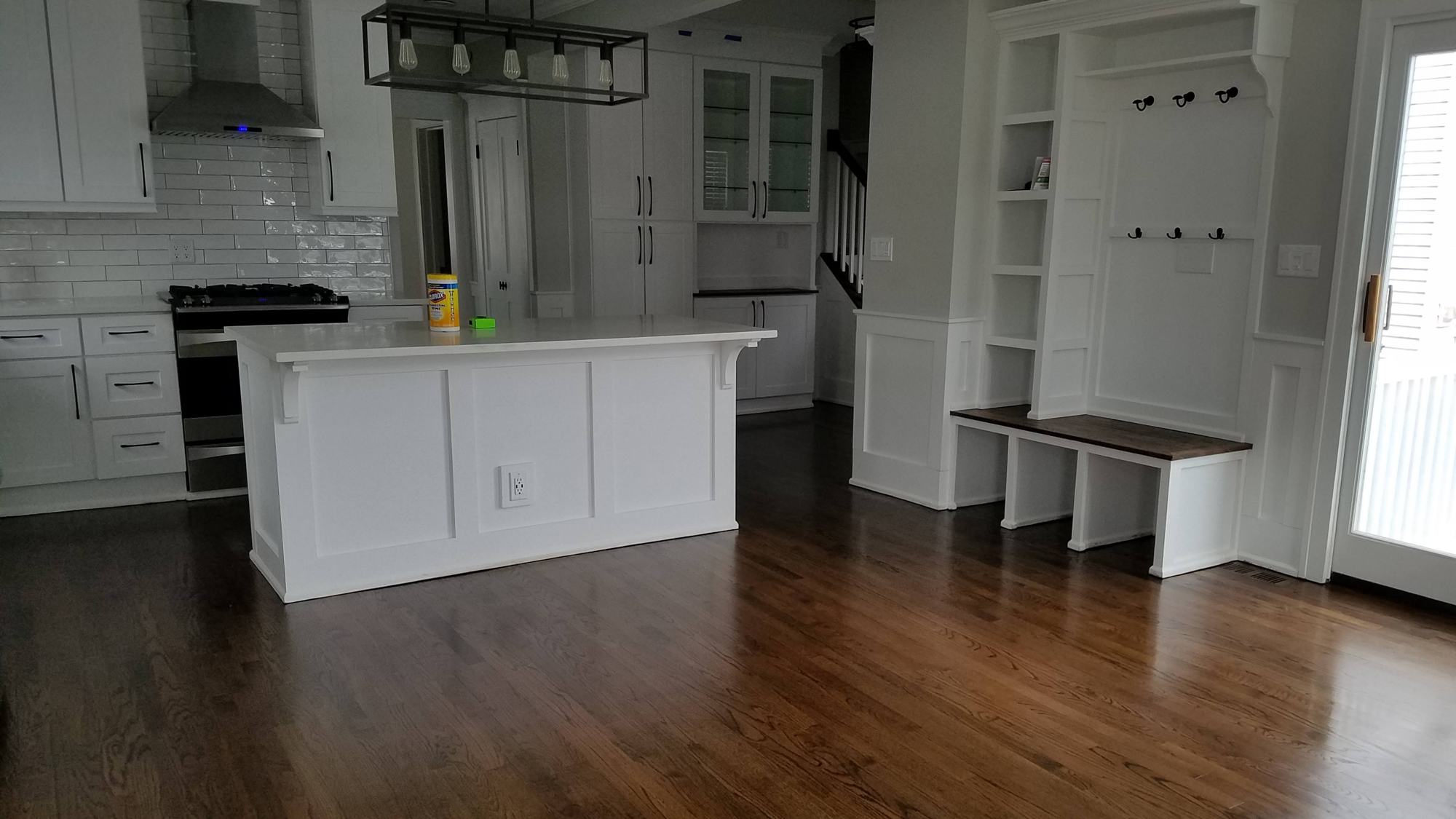 Dark hardwood floor installed through an open kitchen and living area